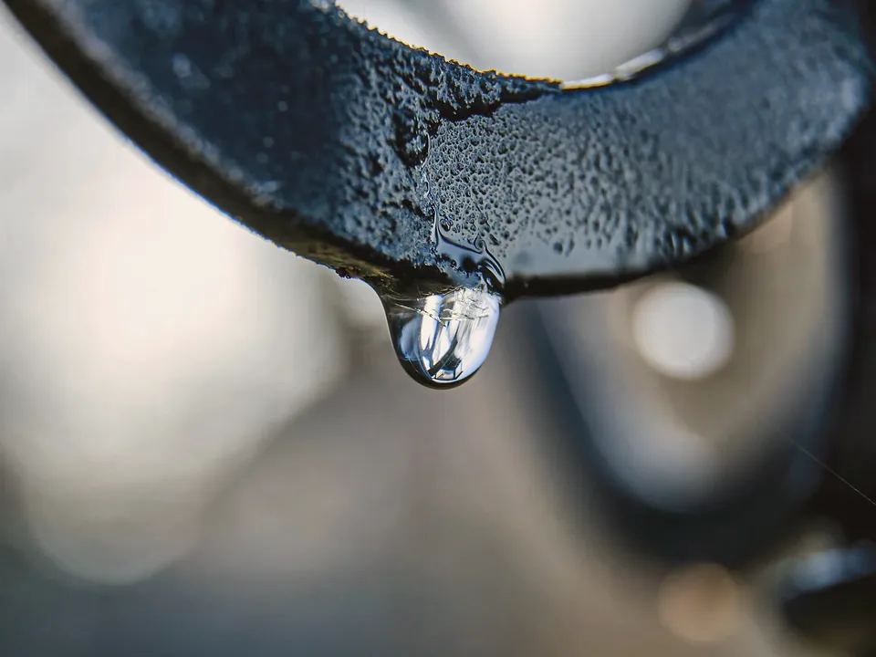 Drop of water hanging from a faucet spout