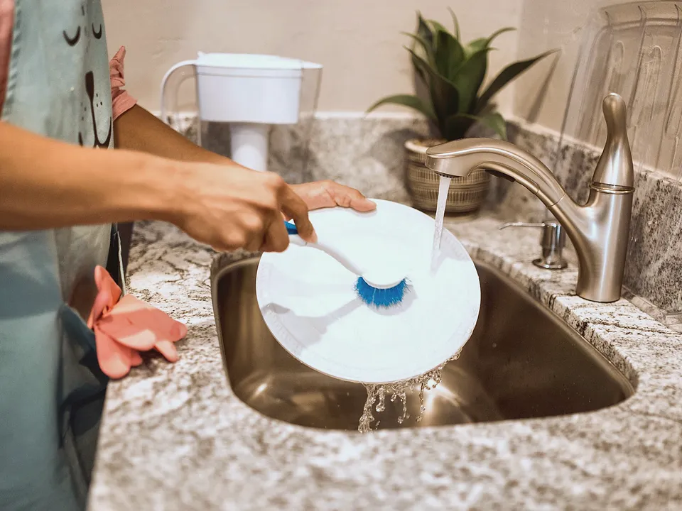 Rinsing a dish in a kitchen sink