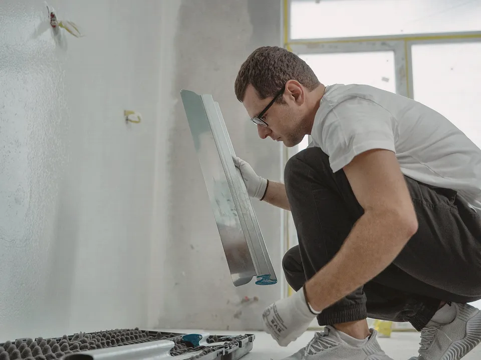 Plasterer smoothing a wall with a trowel