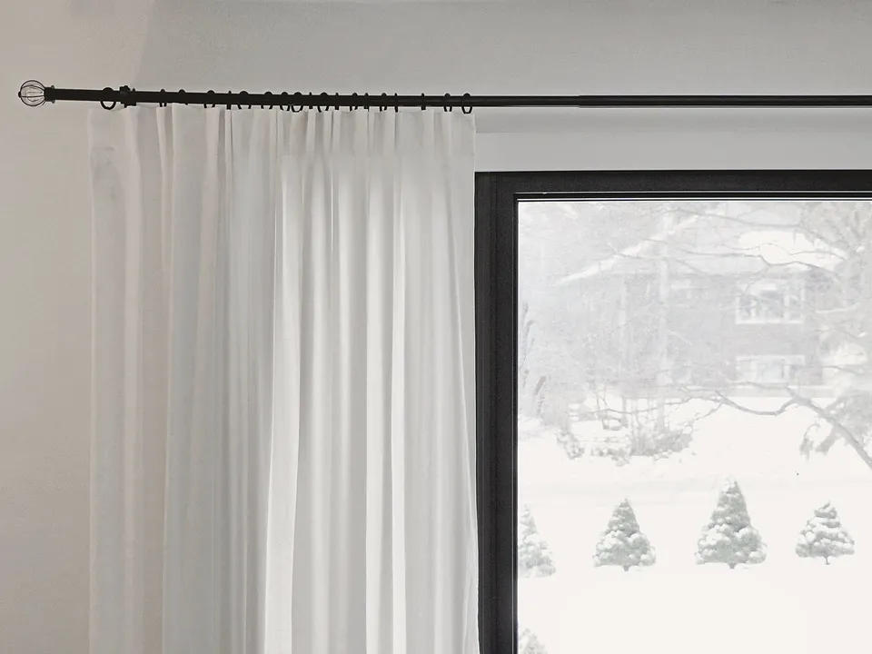 Curtain rod and sheer curtain over a window