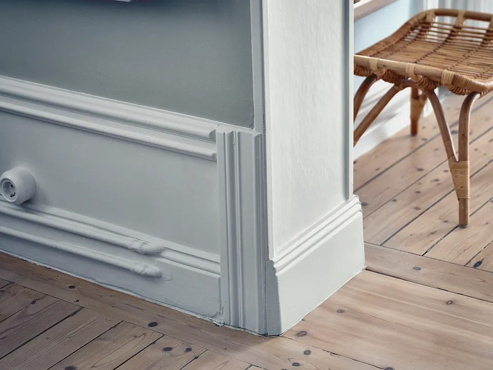 White painted baseboard and wall paneling