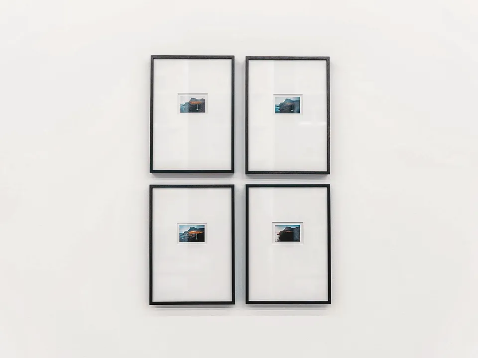Four black frames hung in a tight grid