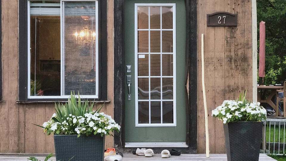 Front entry with a wall light beside a glass door
