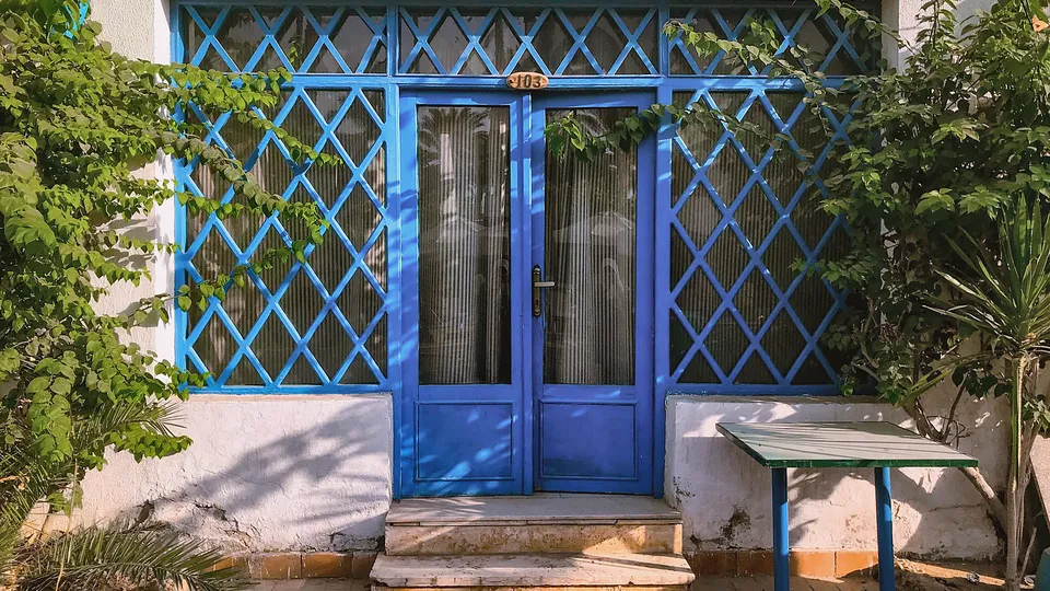 Blue metal security door at a whitewashed entry
