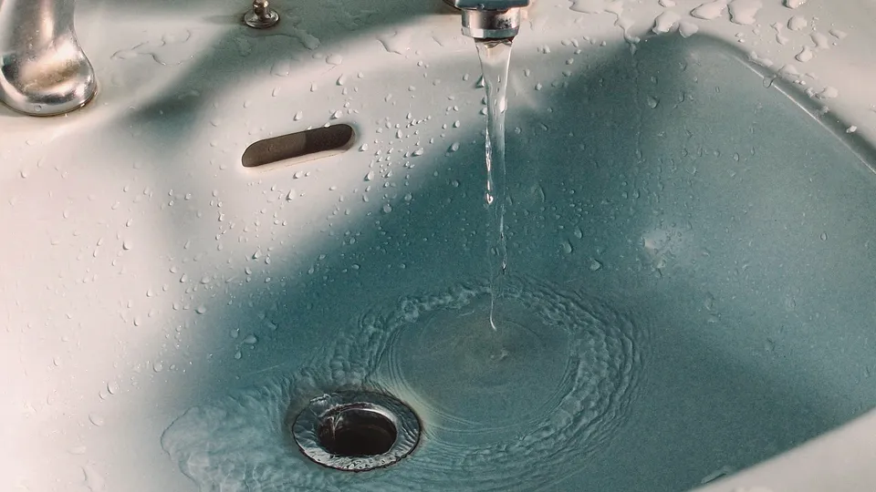 Water draining from a pale blue sink