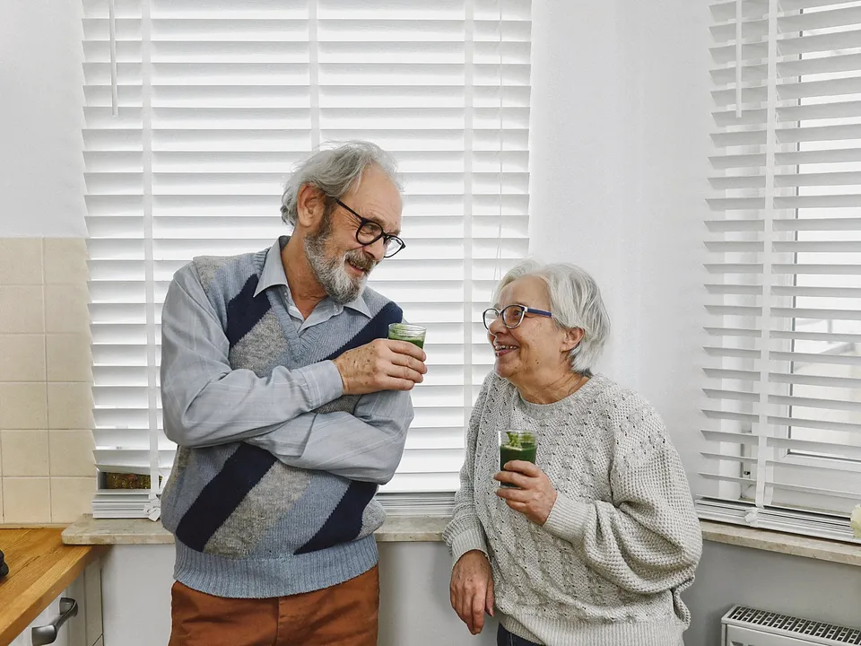 Older couple talking in a bright kitchen