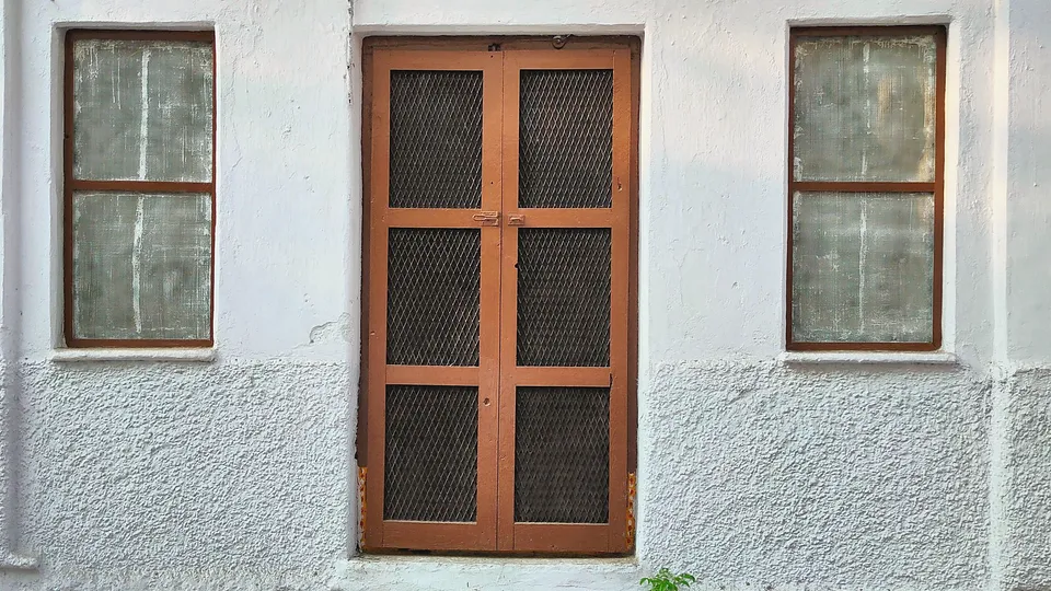 Wood-framed windows in a white plaster wall