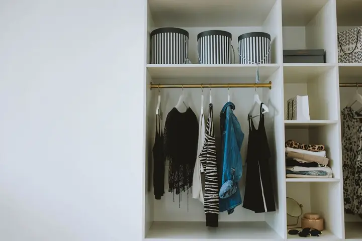 Organized wardrobe with trendy clothes, hangers, and storage boxes