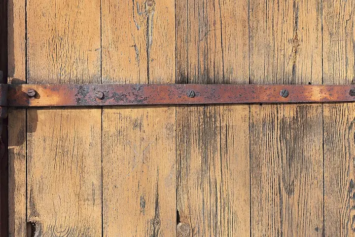 Long iron hinge on a wood door