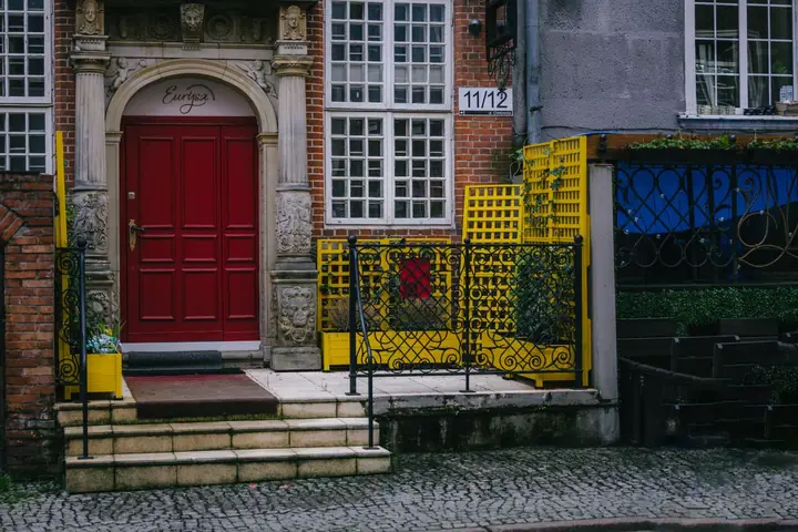 Urban entrance with ornate red door and bright yellow accents