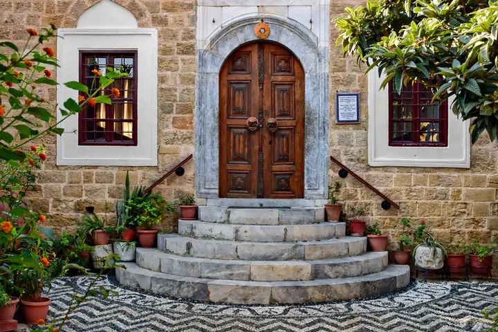 Stone building with arched doorway and decorative pavement