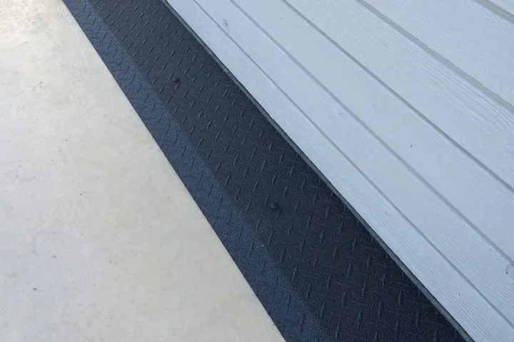 Black rubber transition strip where a floor meets a door