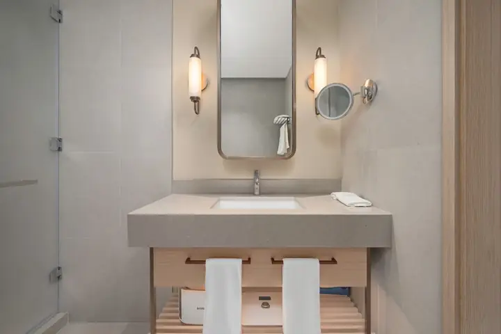 Vanity with a tall mirror between two wall sconces