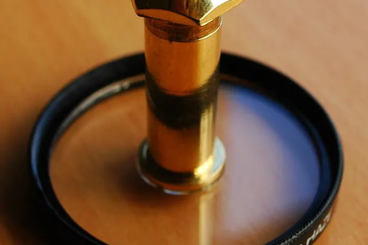 Brass door peephole viewer standing upright on a wooden table