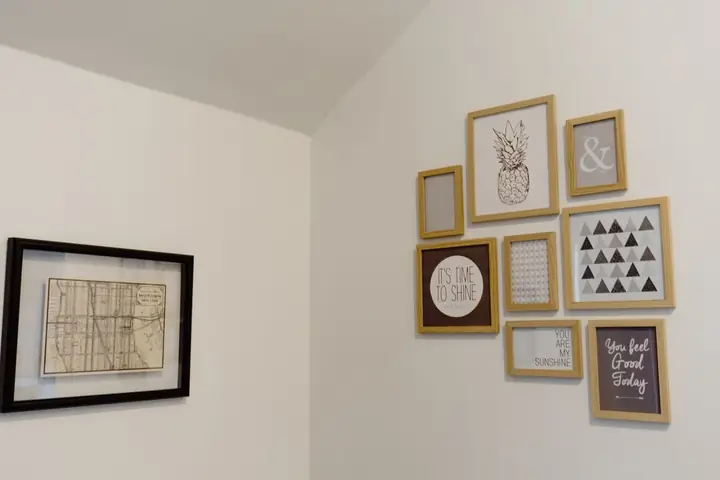 Group of small framed prints hung on a white wall