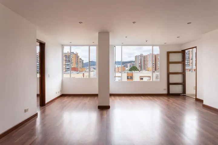 Empty room with wood floors and two tall windows