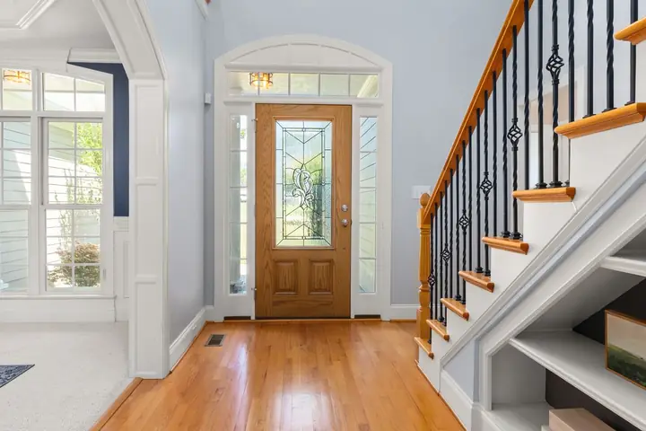 Entry with a wood front door, sidelights and a staircase